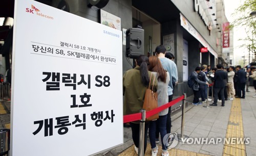 资料图片:4月18日,在位于首尔钟路区的一家手机销售店,预约购买三星Galaxy S8的用户排长龙。(韩联社)