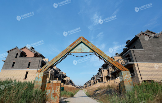 烂尾的别墅区域，临时搭建的大门锈迹斑斑。