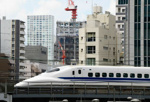 2013年9月，一辆新干线列车行驶在日本东京的楼群之间。（新华社）