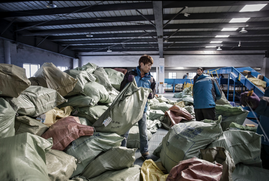 中通快递上海的一个分拣点，一名员工在处理一大堆包裹
