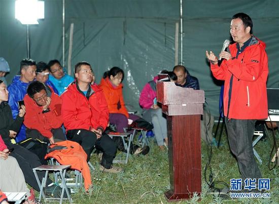 8月18日，暨南大学教授费勇（右）在临时搭建的帐篷内为学生授课。