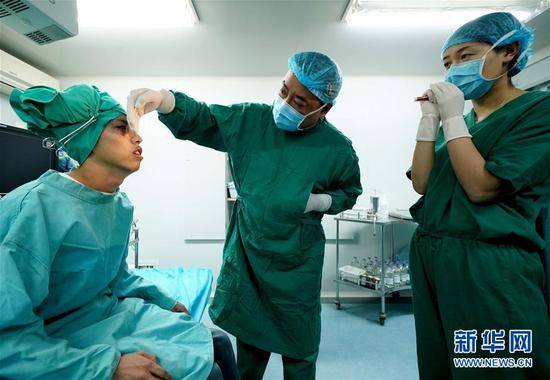 兰州普瑞眼科医院医生张国文（中）和护士在手术室为高三学生罗进荣（左）进行术中检查（8月12日摄）。