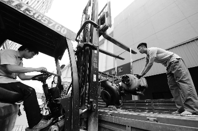 在酒仙桥乐天玛特超市，工作人员将拆下来的电机装车，准备送往拆解公司   摄/记者 曹博远