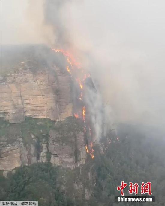 近日,澳大利亚野火蔓延进悉尼郊外的世界遗产蓝山国家公园,园内山峰的悬崖上形成“火瀑布”。目前,该公园已禁止游客入园,并暂停所有活动。