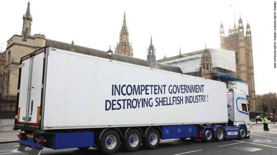 一辆卡车驶过国会大厦，以抗议英国退欧后的繁琐的交易流程。