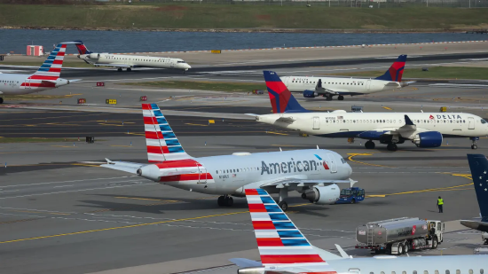 2025 年 11 月 7 日，美国纽约皇后区拉瓜迪亚机场，美国航空与达美航空的飞机停靠在停机坪。美国史上最长政府停摆打乱航空出行秩序，全美航司纷纷取消后续航班，数千名旅客被迫调整出行计划。