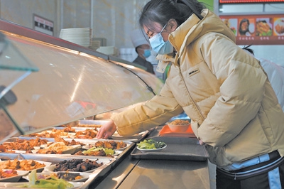 在青海省西宁市第五高级中学食堂，学生在挑选小碗菜。 　　人民视觉