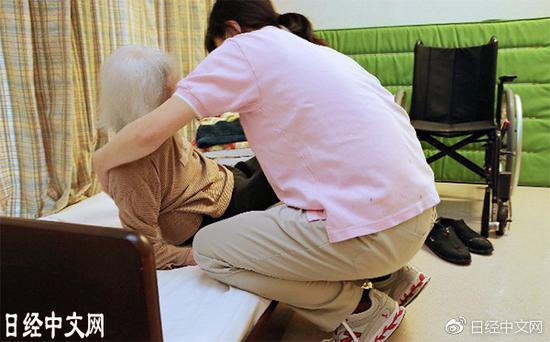 看护设施的工作人员正在照顾老年痴呆症患者