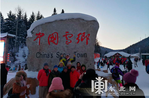 抵达雪乡的游客在“中国雪乡”石碑前合影,见证到此一游。
