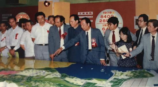 1985年，深圳经济特区工业产品陈列馆开幕，市领导梁湘、李灏、周溪舞、邹尔康（右五至右八）等在现场参观。