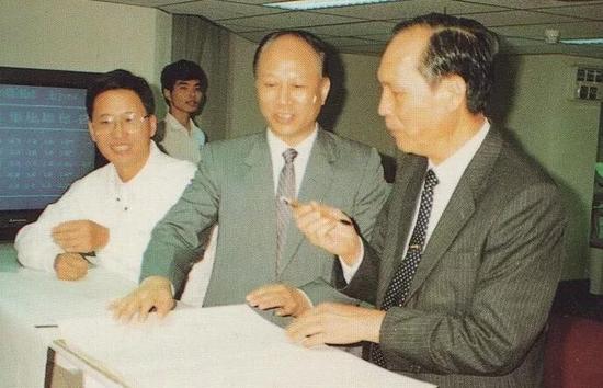 1990年9月,李灏(右一)与时任市长郑良玉(右二)视察深交易所时在电脑辅助系统演示屏题字,并当日拍板定下开业时间。左一为原深交所副总经理禹国刚。