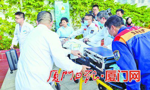 医疗团队将患儿送到急救车上。