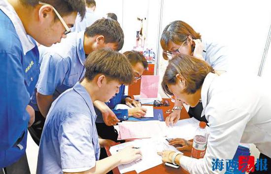 招聘单位代表与学生进行交流。(记者陈理杰摄)