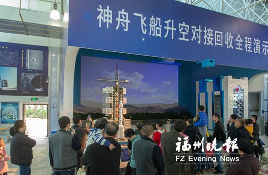 市民们观看神舟飞船升空对接回收全程演示系统。