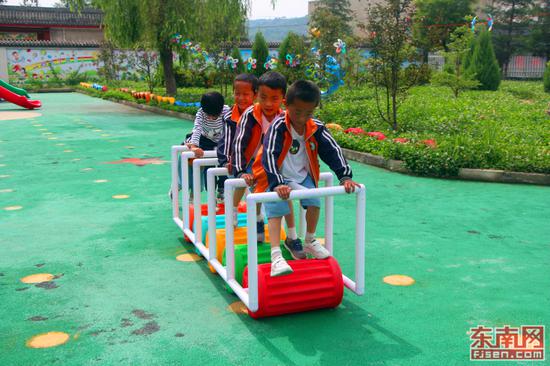 孩子们几人合作玩着踩滚筒的游戏。(东南网记者 刘玮 摄)