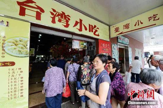 游客在厦门大嶝对台小额商品交易市场品味“舌尖上的台湾”。王东明 摄