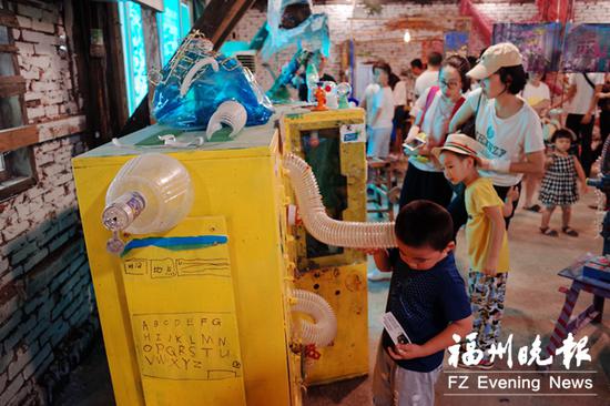 家长带着孩在”垃圾美术馆”参观。