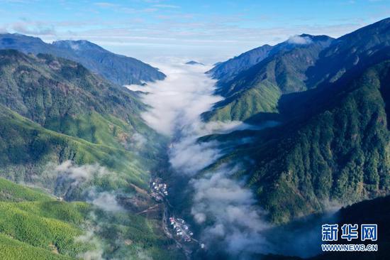 12月1日，武夷断裂带峡谷内云雾缭绕，村庄若隐若现（无人机照片）。