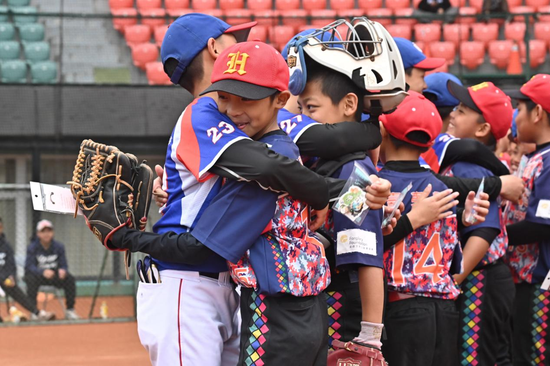　两岸小朋友在奔跑、击球、传球中，情谊不断升温，图为连城县棒球交流团赴台湾开展回访交流活动中，双方队员交流赛后拥抱。