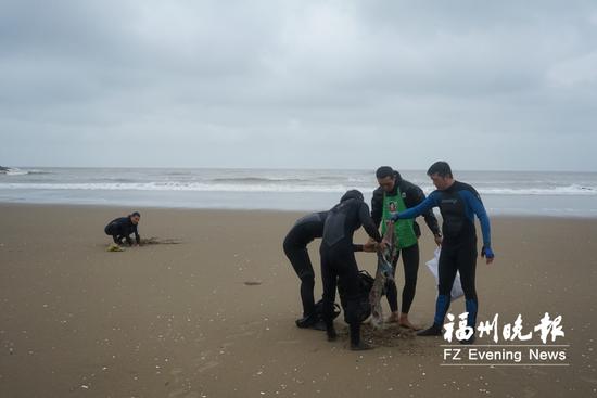 冲浪者清理海漂垃圾。