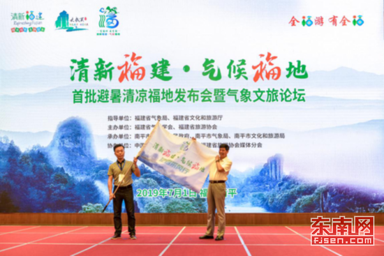 上图为福建省旅游协会副会长兼秘书长洪一树为深入首批避暑清凉福地采访团授旗