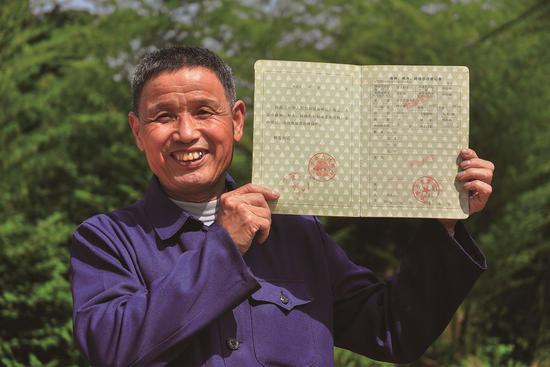 武平县农林李桂林展示他拿到的全国第一本林权证