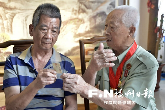 望着吴雄奎当年寄回的老照片，弟弟吴奎俤（左）与当年的战友吴兴水（右）感慨万千。 记者 郑帅 摄