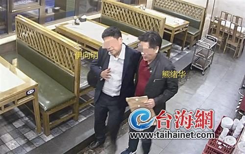 ▲熊绪华法官(右)与江旅集团的代理律师伊向明在餐厅“亲密”交谈的视频截图