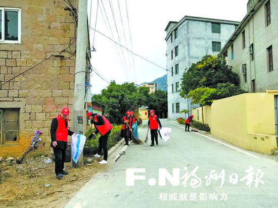 江田镇党员志愿者清理路边垃圾。