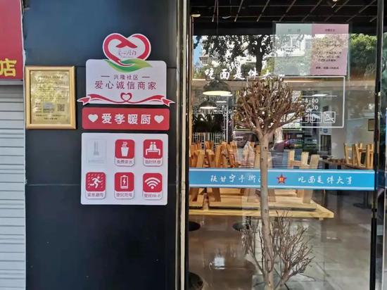 沿街商铺门口挂着“爱心联盟商铺”的牌子,罗列出可提供的服务,如免费充电、免费休憩、免费提供茶水等