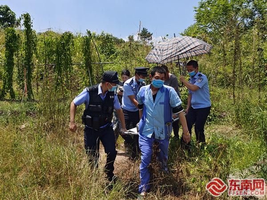 7月22日11时许，民警与医护人员在金泉村一菜地内，将一名高温昏迷男子抬上救护车。沙县公安供图