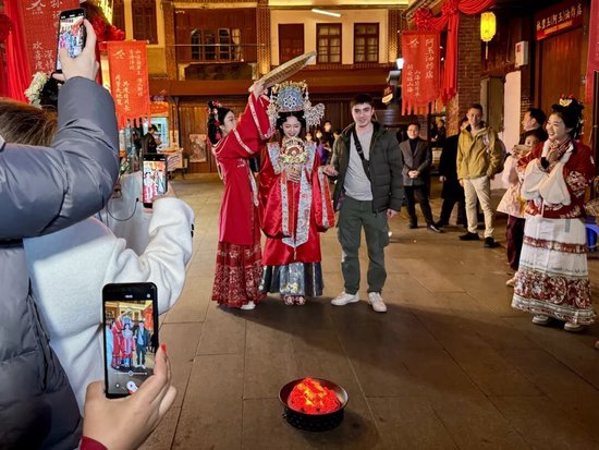 国际旅游达人在漳州古城体验传统婚俗“跨火盆” 张旭 摄