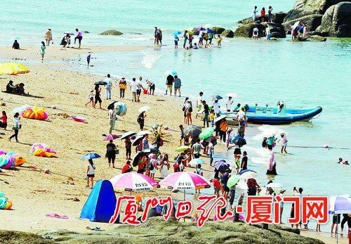 16日上午,天虽热,厦大白城海滩仍吸引不少游人。(姚凡 摄)
