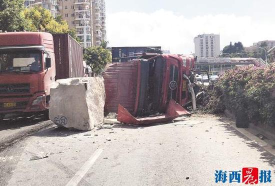 集装箱车侧翻,石材滚落在地。