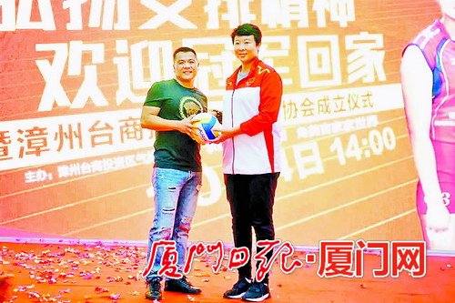女排老队员冯坤(右)送签名球。