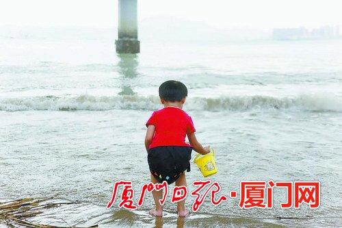 昨日多云升温。图为在海边玩耍的孩童。(本报记者 姚凡摄)