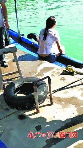 女子被渔民救起后坐在渔船上。(林先生提供)