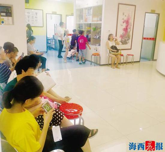 在培训机构等候孩子下课的家长们。 记者 许蔚菡 摄