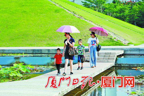 由于阳光炙热,不少市民外出时打伞。(本报记者 王协云 摄)