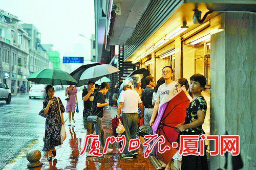 不少行人站在人行道观望雨势。(本报记者 林铭鸿 摄)