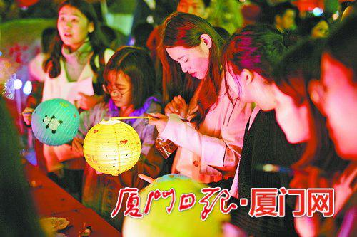 ▲学生们领取纸灯,在?#21414;?#20889;下自己的心愿。