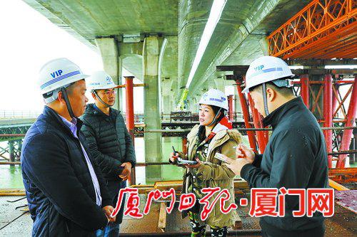记者在施工现场采访建设者。