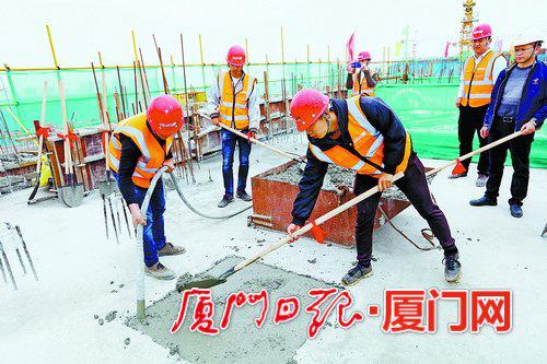工人在最后一小块楼面倒上混凝土。 (本组图/本报记者 张奇辉 林木阳 摄)