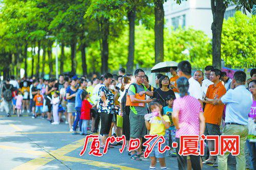小学校园外排队等候报名的家长和学生队伍。(本报记者 林铭鸿 摄)
