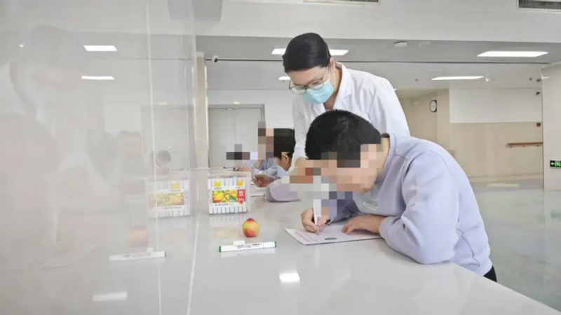 山兰英在工作人员的陪伴下画画