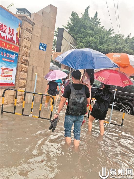 家长抱着孩子涉水进学校报到