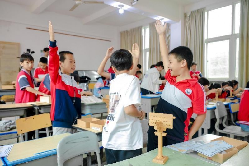 5月27日,在科普达人@杨爸图说 的科普课上,学生们体验搭建斗拱成功并举手示意