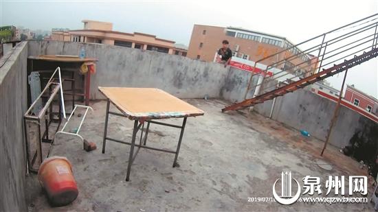 男子坐民房楼顶的围栏上欲轻生(视频截图)