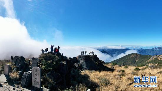 12月1日，人们在云雾缭绕的武夷主峰黄岗山顶参观（无人机照片）。