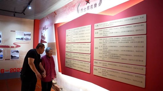 这里登记了解放军庙供奉的27名烈士名录，图为张凯陪奶奶重温烈士名单。东南网记者 杜志鑫 摄